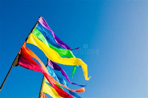 Colorful Rainbow Triangle Flag Shows Up Against the Blue Sky. Stock ...