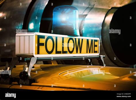 Retro follow me sign of a historic airport vehicle in front of a jet ...