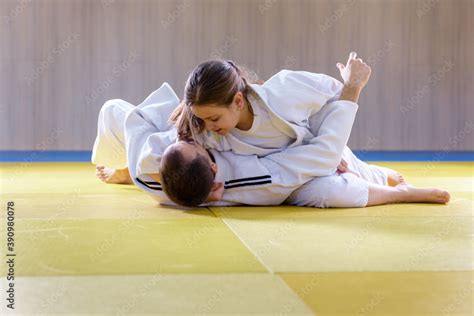 Young female judoka holds older male judoka with kesa gatame technique foto de Stock | Adobe Stock