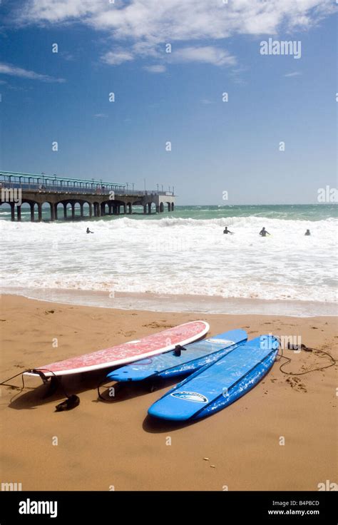 Surfers on Boscombe beach next to Boscombe pier Stock Photo - Alamy