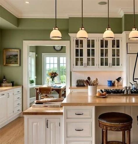a kitchen with two stools in front of an island and three lights above it