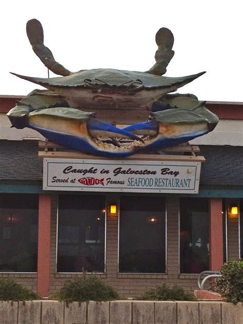 a large crab on top of a restaurant sign