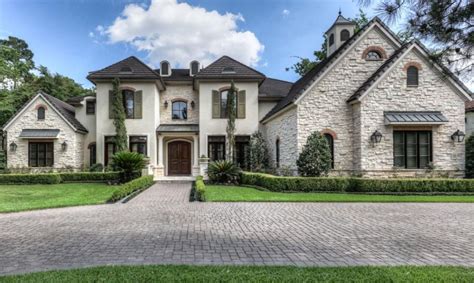 This French Country style stone & stucco home is located at 15 Hepplewhite Way in Spring, TX and ...