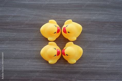 yellow duck toy on a wooden texture background with various combinations of formations and ...