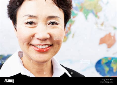 Chinese woman smiling by world map Stock Photo - Alamy