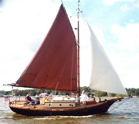 a sailboat with two people on it in the water