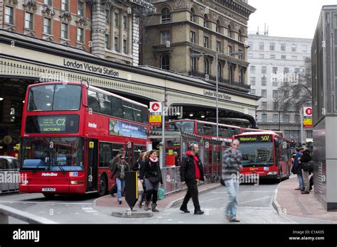 London`s famous red buses at Victoria bus station, commuters and ...