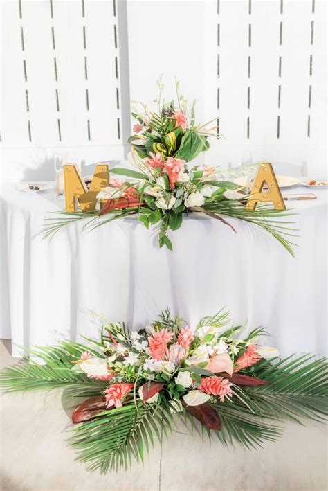 two flower arrangements on top of a table with the letters ma and m ...