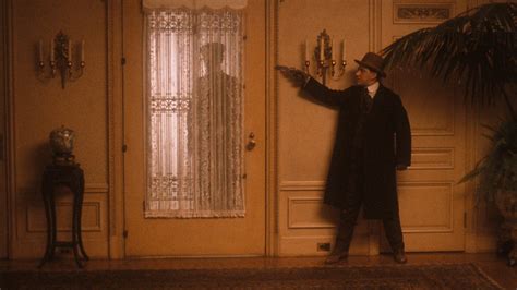 a man standing in front of a door with his hand out and pointing at something