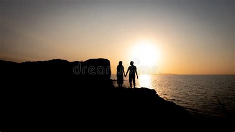 A Couple of Lovers Holding Hands at Sunset by the Sea Stock Image ...