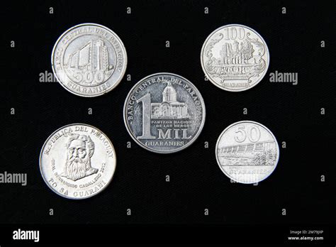 paraguay guaranies coin - set of paraguayan coins in a row isolated on black background Stock ...