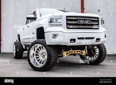 A white lifted GMC truck parked outdoors Stock Photo - Alamy