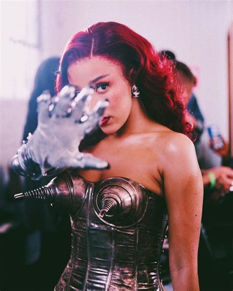 a woman with red hair and silver gloves