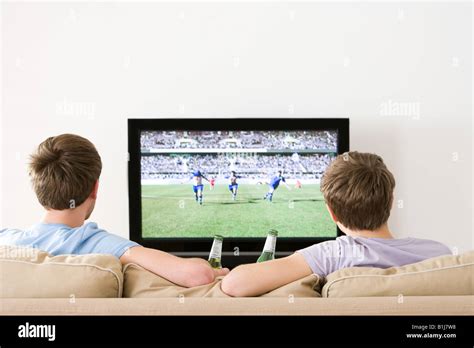 Two young men watching football on the tv Stock Photo, Royalty Free ...