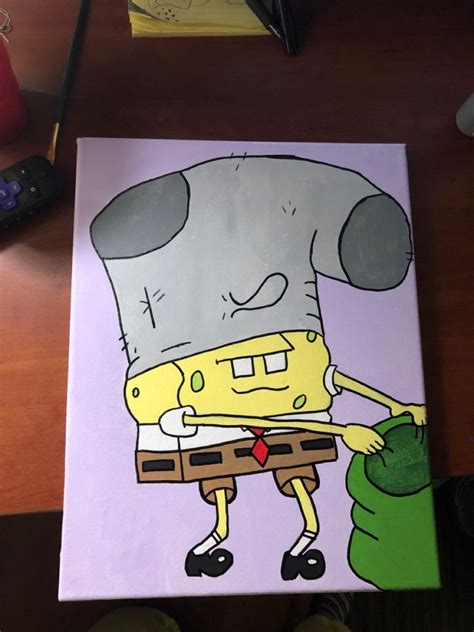 a drawing of a spongebob holding a green bag on a wooden table next to a remote control