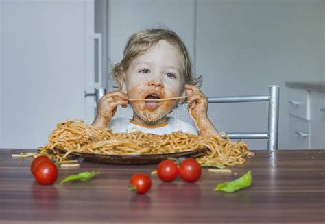 Funny Baby Child Getting Messy Eating Spaghetti with Tomato Sauce from ...