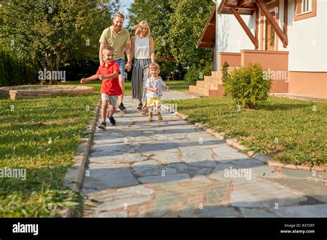 Happy family in garden of their home Stock Photo - Alamy