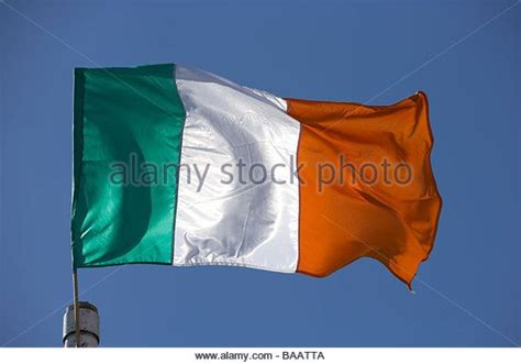 Irish tricolour green white and orange flag flying against blue sky in ireland… | Ireland flag ...