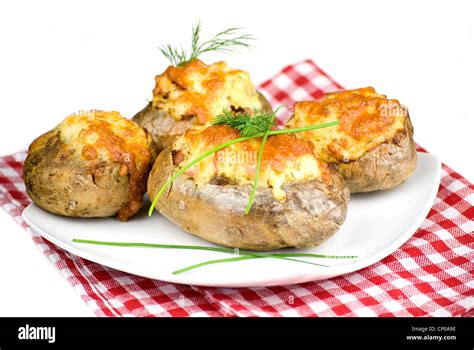 stuffed potatoes covered with cheddar cheese decorated with chives and dill leaves in a white ...