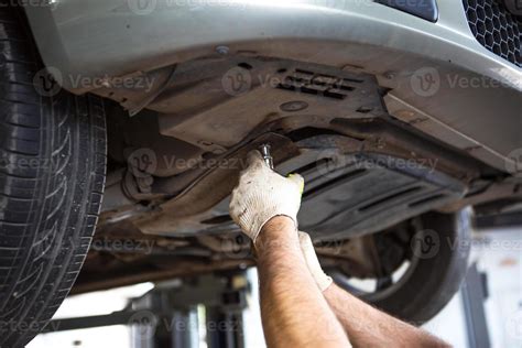 The car is lifted for repair on a lift in a car service station, a ...