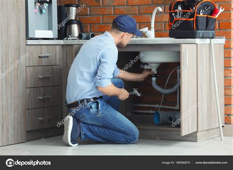 Professional plumber fixing kitchen sink Stock Photo by ©belchonock 186080874