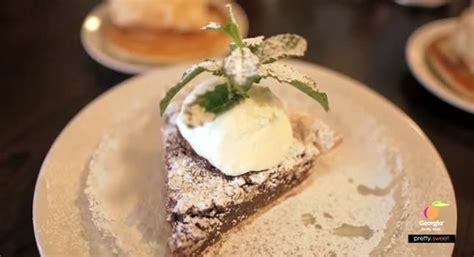 a piece of pie on a white plate with whipped cream and green garnish