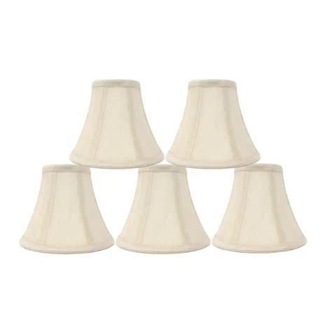 four white lampshades are lined up in a row