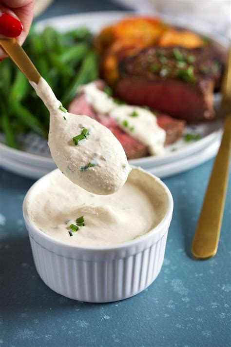 Creamy Horseradish Sauce on a gold spoon over a bowl of horseradish ...