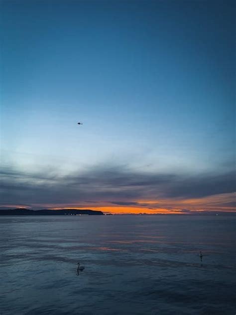 Yellow Sky over Sea Coast at Sunset · Free Stock Photo