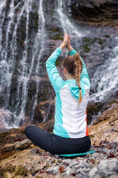 Meditation in Nature, a Girl Relaxing in a Yoga Pose Near a Waterfall ...