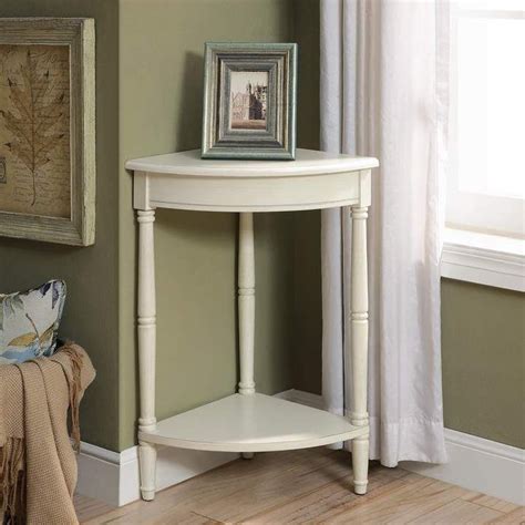 a white corner table with a framed picture on the shelf next to it in a ...