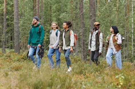 Premium Photo | Diverse group of young people walking in forest with ...