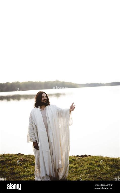 Vertical shot of Jesus Christ smiling and lending a hand for help Stock Photo - Alamy