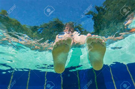 Girls Feet on water surface underwater view swimming pool summers day ...