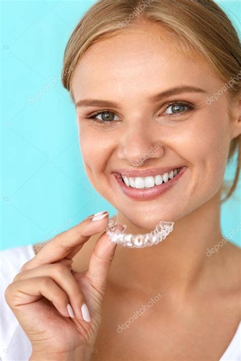 Smiling Woman With Beautiful Smile Using Teeth Whitening Tray — Stock Photo © puhhha #120489604