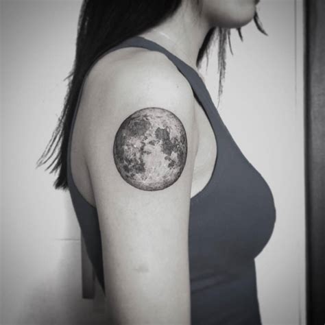 Full moon tattoo on the right upper arm.