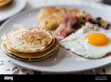 A breakfast with eggs, pancakes, bacon and hash browns Stock Photo - Alamy