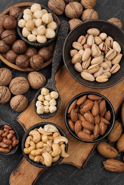 Free Photo | Organic nuts snack in bowls on wooden board