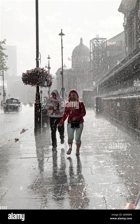 People walking in heavy rain in wet summer 2016 on a street in Stock ...