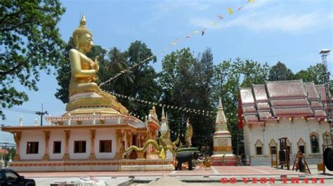 a large golden buddha statue sitting in front of a white building with ...