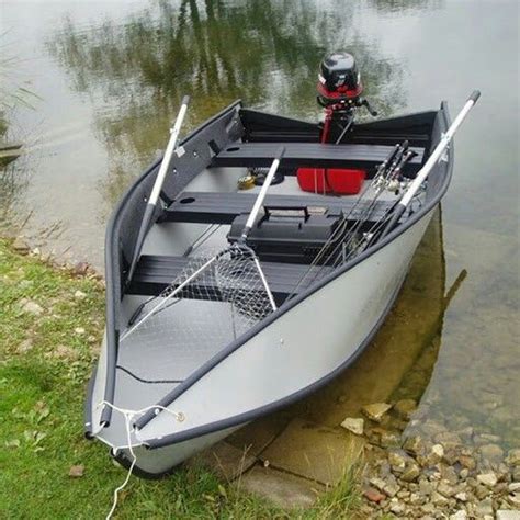 a small boat sitting on top of a river next to a grass covered shore line