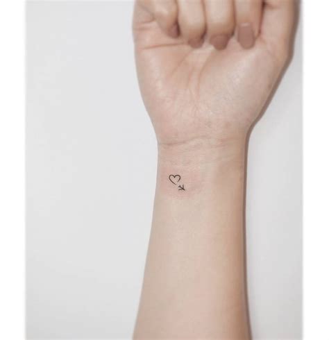 Minimalistic heart and plane tattoo done on the wrist.