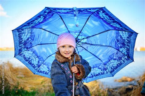 Little girl and boy with umbrella playing in the rain. Kids play ...