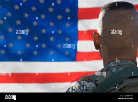US Army soldier looking at flag, back view Stock Photo - Alamy