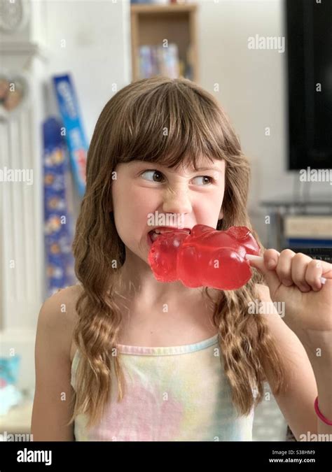 Girl Eating Giant Gummy Bear Sweet Stock Photo - Alamy