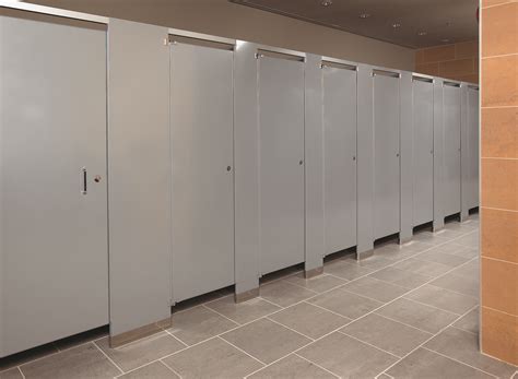 a row of stalls in a public restroom with tile flooring and walls lined with metal doors