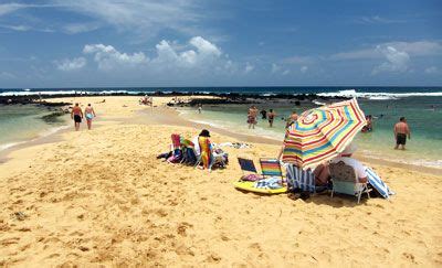 people are on the beach with umbrellas and chairs in the sand near the water