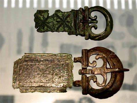 Two Roman belt buckles and plates. The top one is of a early Augustan style, belonging to a thin ...