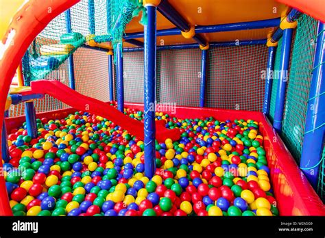 Colored plastic balls in pool of game room. Swimming pool for fun and jumping in colored plastic ...