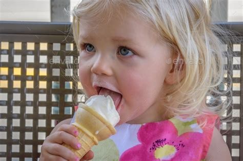 Toddler girl licking ice cream cone Stock Photo by krisprahl | PhotoDune